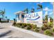 Aqua community sign with vibrant landscaping, a welcoming entrance, and palm trees at 6028 Red Mangrove Ln, Bradenton, FL 34210