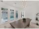 Dining room with contemporary table, stylish chairs, bench seating, modern light fixture, and view of the pool at 6028 Red Mangrove Ln, Bradenton, FL 34210