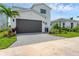 Featuring a spacious two car garage and grey paved driveway that matches the surrounding landscaping at 6028 Red Mangrove Ln, Bradenton, FL 34210