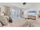 Bright primary bedroom with a large bed, sliding glass doors, and beach view on TV at 6028 Red Mangrove Ln, Bradenton, FL 34210