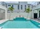 Private outdoor pool surrounded by a white concrete fence with a multi-level feature and gray stone pavers at 6028 Red Mangrove Ln, Bradenton, FL 34210