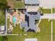 Aerial view of home featuring landscaped yard, pool, pergola, and solar panels at 6178 Coliseum Blvd, Port Charlotte, FL 33981