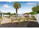 Expansive backyard featuring tropical landscaping, a pergola, and a charming water feature at 6178 Coliseum Blvd, Port Charlotte, FL 33981