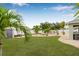 Lush backyard with ample green space, tropical landscaping, and brick paver accents at 6178 Coliseum Blvd, Port Charlotte, FL 33981