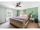 Bedroom with a ceiling fan, green accent wall, and backyard view at 6178 Coliseum Blvd, Port Charlotte, FL 33981