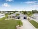 Inviting single-story home with green grass, palm trees and a long driveway leading to the front garage at 6178 Coliseum Blvd, Port Charlotte, FL 33981