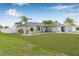 Charming home exterior with lush lawn and tropical landscaping at 6178 Coliseum Blvd, Port Charlotte, FL 33981