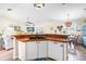 Bright kitchen featuring white cabinets, a peninsula island, and a view into the adjacent dining area at 6178 Coliseum Blvd, Port Charlotte, FL 33981