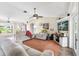 Spacious living room with comfortable seating, a ceiling fan, and a view of the home's vibrant yard at 6178 Coliseum Blvd, Port Charlotte, FL 33981