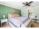 Cozy bedroom featuring a ceiling fan, ensuite bathroom, and light green walls at 6178 Coliseum Blvd, Port Charlotte, FL 33981