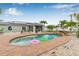 Beautiful backyard pool with waterfall feature, tropical landscaping, and brick paver surround at 6178 Coliseum Blvd, Port Charlotte, FL 33981