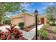 Charming one-story home featuring a manicured front yard with colorful landscaping and a cozy, inviting entrance at 6352 Robin Cv, Lakewood Ranch, FL 34202