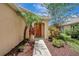 Inviting front entrance showcasing a well-maintained walkway framed by lush tropical plants and mulch at 6352 Robin Cv, Lakewood Ranch, FL 34202