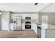 Bright kitchen featuring white cabinets, stainless steel appliances, granite countertops, and modern flooring at 6352 Robin Cv, Lakewood Ranch, FL 34202