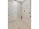 Well-lit laundry room with tile flooring, overhead shelving, and a full-sized door to maximize efficiency at 6352 Robin Cv, Lakewood Ranch, FL 34202