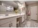 Bathroom with double vanity sinks, white cabinetry, decorative rug, and glass shower at 640 Encarnacion St, Punta Gorda, FL 33983