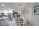 Bright dining area features a chandelier over a wood table next to the white kitchen at 640 Encarnacion St, Punta Gorda, FL 33983