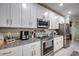 Modern kitchen with stainless steel appliances, granite countertops, and white cabinets at 640 Encarnacion St, Punta Gorda, FL 33983