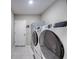 Efficient laundry room with modern washer and dryer units, complemented by neutral tile flooring at 640 Encarnacion St, Punta Gorda, FL 33983
