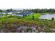 Aerial view of a gray house with a screened patio overlooking a large pond at 6435 165Th E Dr, Parrish, FL 34219