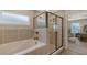 Modern bathroom features a glass shower, tile surround bathtub, and a window for natural light at 6435 165Th E Dr, Parrish, FL 34219