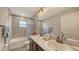 Bathroom features a double sink vanity, a window, and a bathtub with shower at 6435 165Th E Dr, Parrish, FL 34219