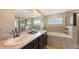 Bright bathroom with double sinks, soaking tub, and sleek glass shower in neutral tile at 6435 165Th E Dr, Parrish, FL 34219