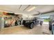 Spacious garage with a parked black truck, storage shelves, and ample room for parking at 6435 165Th E Dr, Parrish, FL 34219