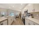 Bright, open kitchen with modern appliances, white cabinetry, and a view of the dining area at 6435 165Th E Dr, Parrish, FL 34219