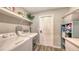 Well-equipped laundry room with modern washer, dryer, storage shelves and neutral walls at 6435 165Th E Dr, Parrish, FL 34219