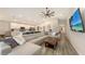 Open-concept living room features a large sectional couch and flows into the kitchen with modern appliances at 6435 165Th E Dr, Parrish, FL 34219