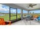 Enclosed patio with a ceiling fan and a view of a lush green space and a pond at 6435 165Th E Dr, Parrish, FL 34219