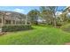 Expansive backyard with a manicured lawn and screened patio, perfect for outdoor enjoyment at 7012 Treymore Ct, Sarasota, FL 34243