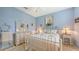 Bedroom with a fan, shutters and wicker chair against a pastel blue wall at 7012 Treymore Ct, Sarasota, FL 34243