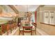 Bright dining room with a tropical mural, glass table, and large windows with stylish curtains at 7012 Treymore Ct, Sarasota, FL 34243