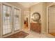 Bright foyer with tile flooring, double doors, and decorative furnishings at 7012 Treymore Ct, Sarasota, FL 34243