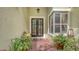 Elegant front door with sidelight, brick patio, and inviting potted plants at 7012 Treymore Ct, Sarasota, FL 34243