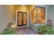 Inviting front porch with brick pavers, a wooden bench, and lush ferns near a door and large window at 7012 Treymore Ct, Sarasota, FL 34243
