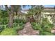 Charming home featuring lush landscaping, brick walkway, and a well-maintained exterior at 7012 Treymore Ct, Sarasota, FL 34243