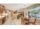 Open kitchen and dining space with views of the living room, breakfast bar, and outdoor entertaining area at 7012 Treymore Ct, Sarasota, FL 34243