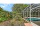 Exterior view showing screened in patio with lush garden at 7012 Treymore Ct, Sarasota, FL 34243
