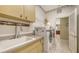 Functional laundry room with stainless sink, light wood cabinets, and modern washer and dryer at 7012 Treymore Ct, Sarasota, FL 34243