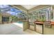 Outdoor kitchen with built in barbecue, stainless steel appliances and bar overlooking sparkling swimming pool at 7012 Treymore Ct, Sarasota, FL 34243