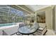 Outdoor living space featuring a screened patio, swimming pool and elegant outdoor dining set at 7012 Treymore Ct, Sarasota, FL 34243