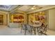 A covered patio features a dining table, ceiling fan and views of the kitchen and living room through glass windows and sliding doors at 7012 Treymore Ct, Sarasota, FL 34243
