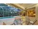 Screened in pool with covered patio with dining, partial kitchen and view of the home's open floor plan at 7012 Treymore Ct, Sarasota, FL 34243