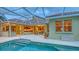 A refreshing swimming pool in a screened enclosure offers a relaxing retreat with a view of the tiled roof and patio at 7012 Treymore Ct, Sarasota, FL 34243