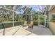 Relaxing screened in patio with outdoor seating surrounded by lush landscaping at 7012 Treymore Ct, Sarasota, FL 34243