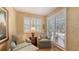 Light-filled sitting area with two chairs, table and large windows with shutters at 7012 Treymore Ct, Sarasota, FL 34243