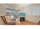 Bright sun room with tile floor, sliding glass door and screen room with outdoor kitchen beyond at 7012 Treymore Ct, Sarasota, FL 34243